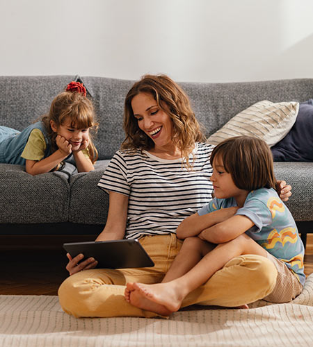 Mom and two kids with tablet at home.